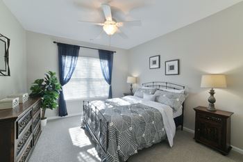 A bedroom with a bed and a ceiling fan